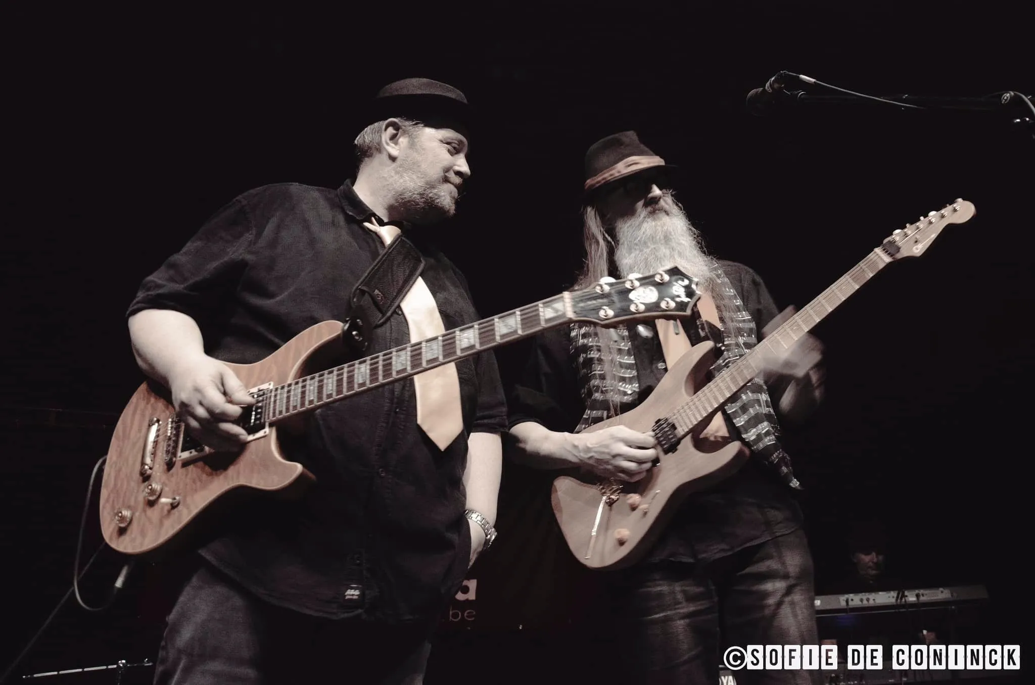 Two Tante Carla guitarists on stage, black and white