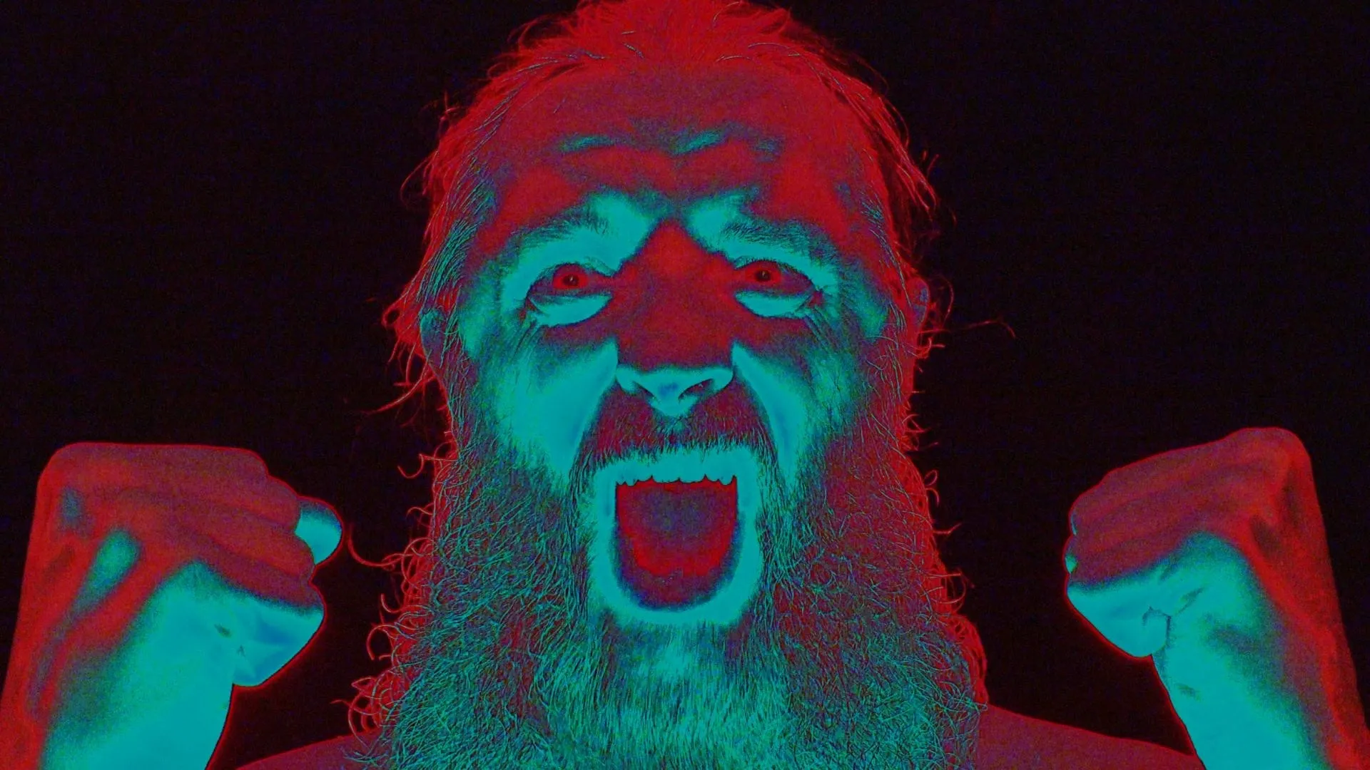 Peter Capon screaming, fists raised, in red and cyan light