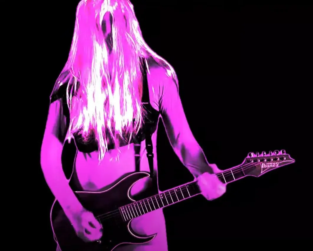 Guitarist with pink hair in pink and black, from the Dikke Tetten video