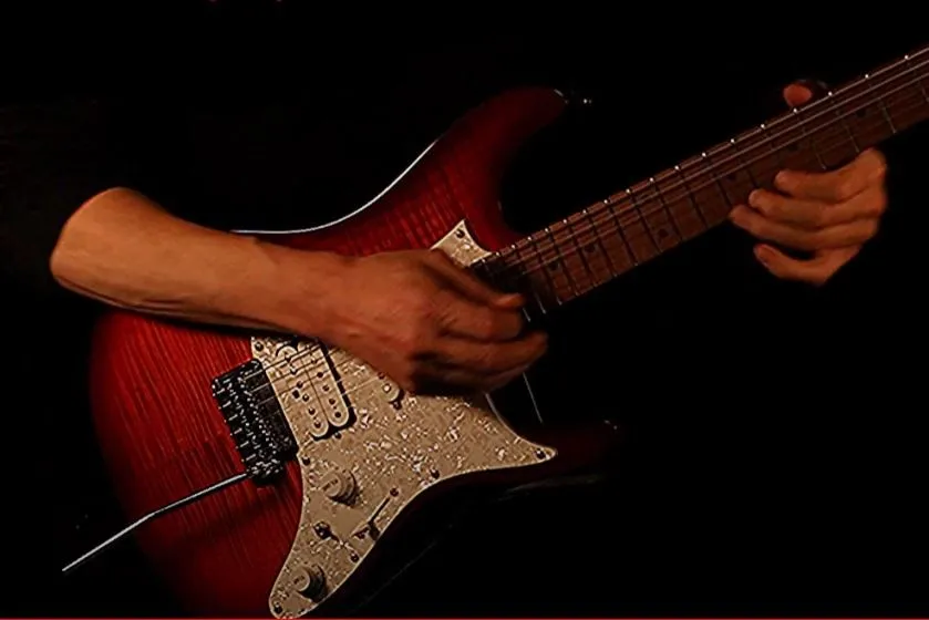 Close-up of a red electric guitar being played