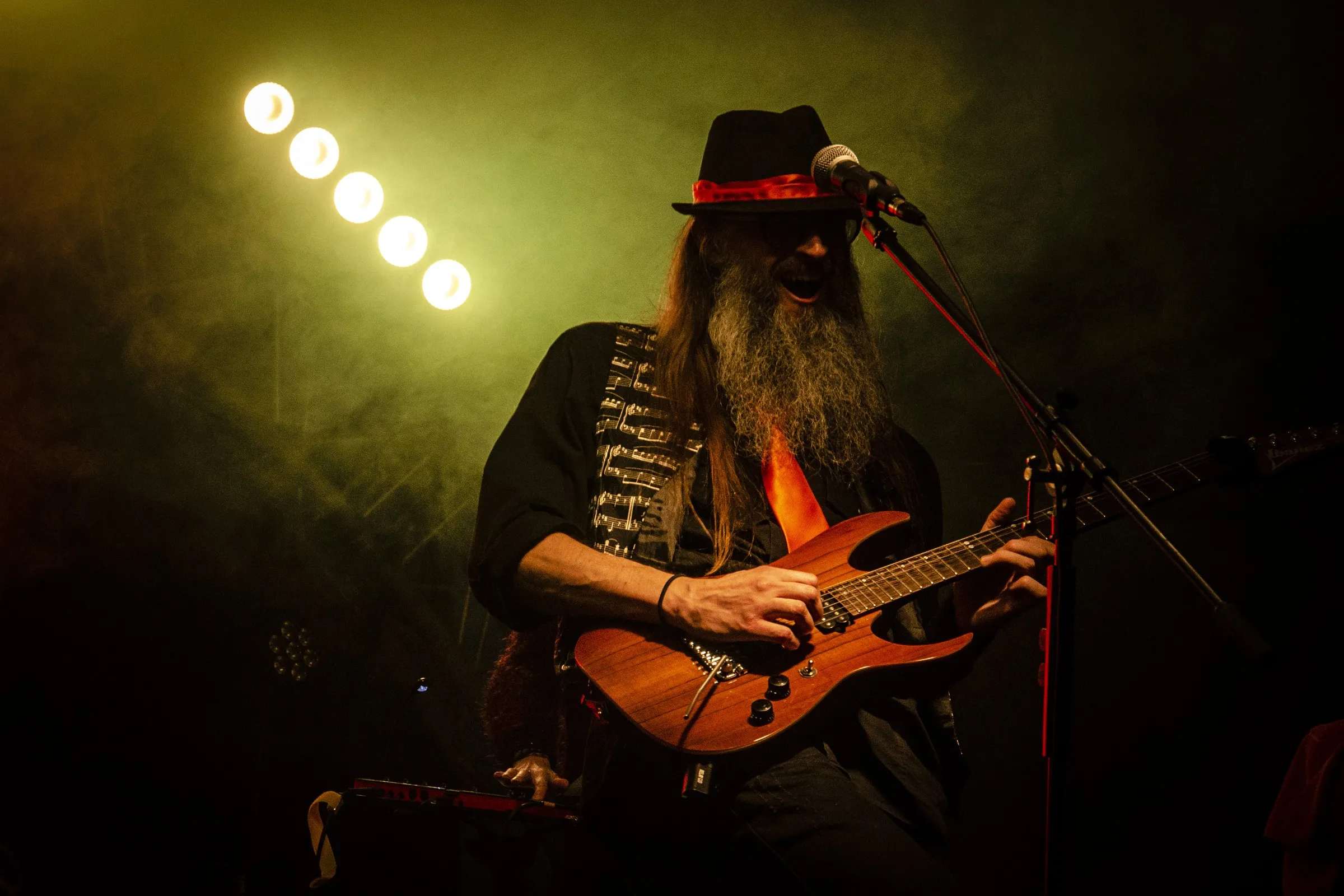 Guitarist playing live under yellow stage lights