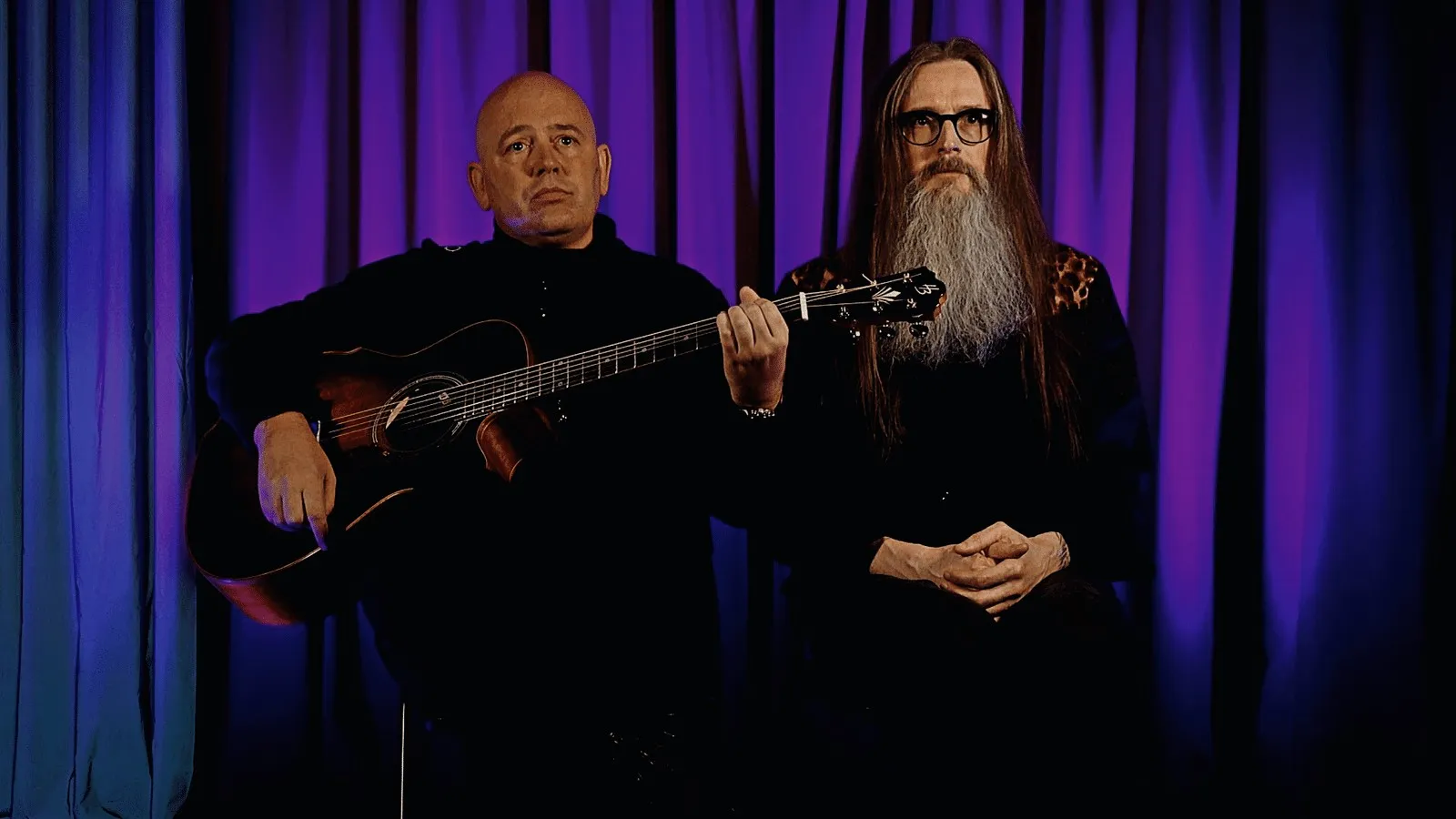 CirCo Di Capo duo with acoustic guitar in front of a blue curtain